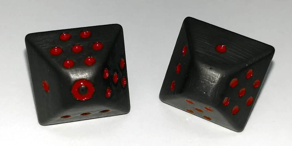 Grey dice painted with red dots.